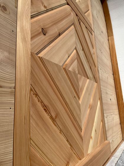 Detailaufnahme eines kunstvoll gearbeiteten Holzpaneels mit geometrischem Muster bei Stark AG Altstätten.