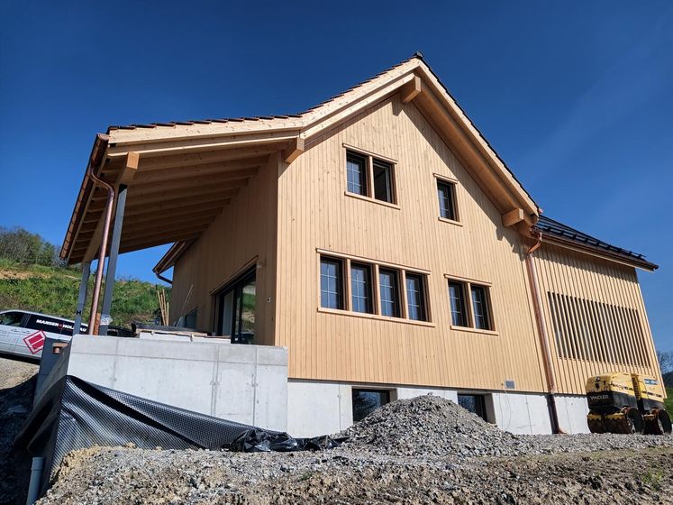 Neues Holzhaus im Bau mit blauer Himmel im Hintergrund.