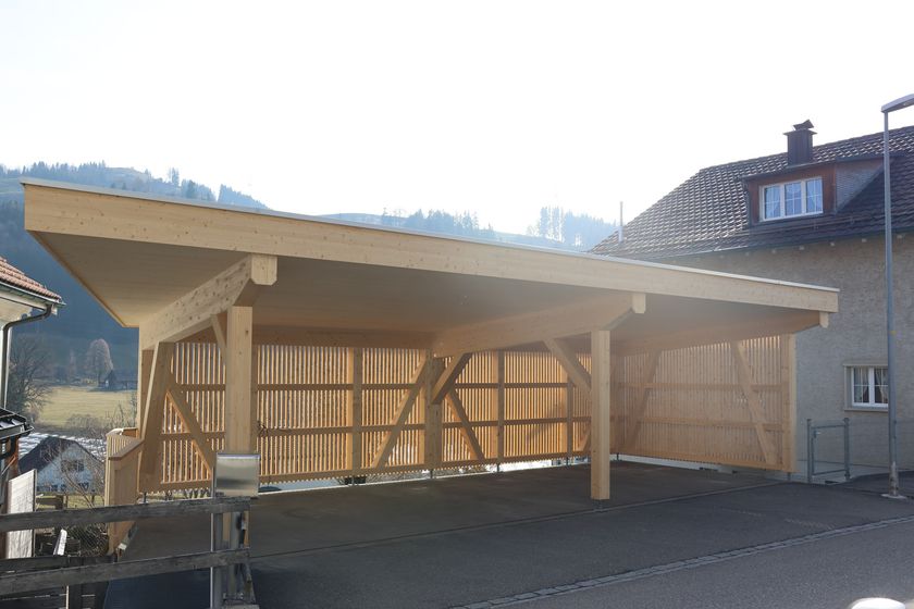 Holzunterstand mit moderner Dachkonstruktion und Umgebung.