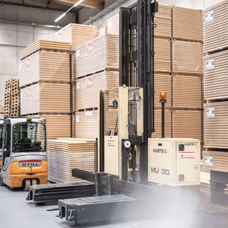 Gabelstapler bewegt Holzplatten in einem modernen Lager.
