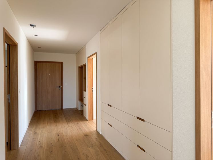 Moderner Flur mit Holzboden und Einbauschränken in einem Innenausbau-Projekt.