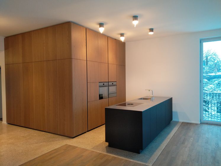 Moderne Küche mit Holzverkleidung und Insel von Stark AG.