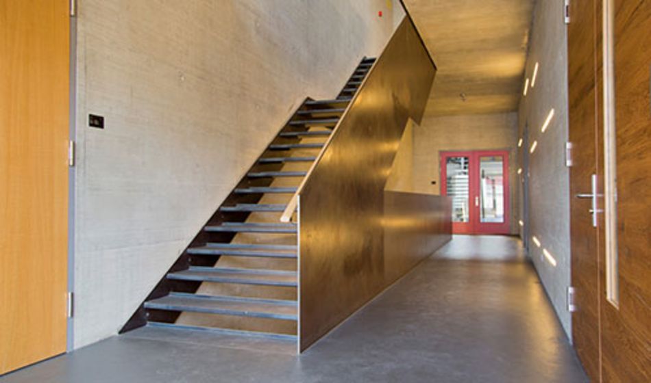 Moderner Treppenhausbereich mit Beton- und Holzelementen.