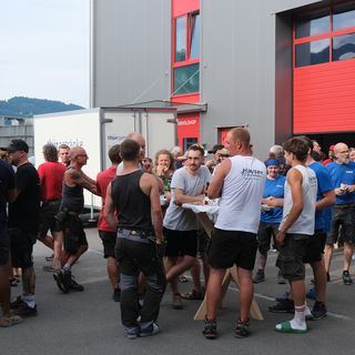 Gruppe von Männern bei einer Pause vor einem Industriegebäude.