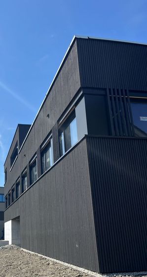 Modernes Holzgebäude unter blauem Himmel.