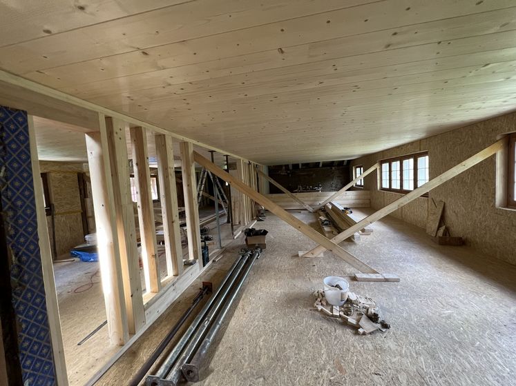 Innenausbau mit Holzmaterialien in einem Raum mit Dachschräge und Stützstreben.