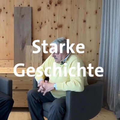 Ein Mann in einem Gespräch, untermalt von einer Holz- und Stoffkulisse, mit dem Text 'Starke Geschichte'.