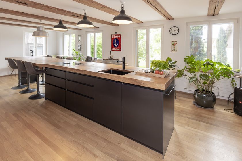 Moderne Küche mit Holzarbeitsplatte und Pflanzen.