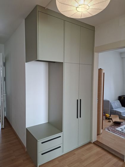 Moderner Einbauschrank aus Holz neben einem Durchgang im Wohnbereich.