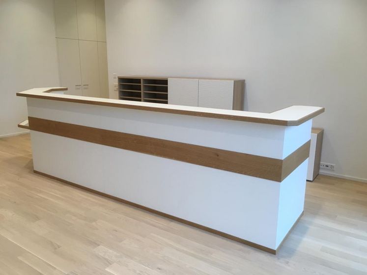 Moderne Empfangstheke aus Holz in einem Büro.