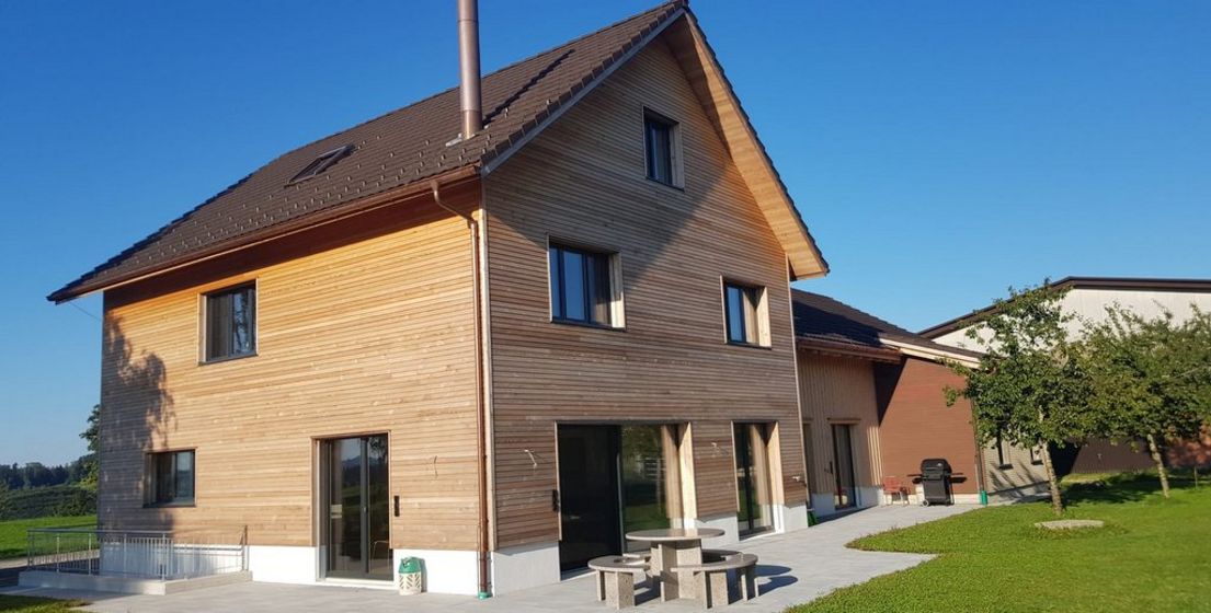 Modernes Holzhaus bei sonnigem Wetter