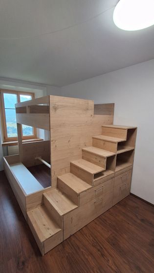 Hochbett aus Holz mit integrierter Treppe und Stauraum in einem hellen Raum.