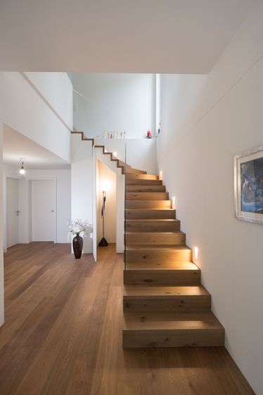 Moderne Holztreppe in einem eleganten Wohnbereich mit stilvollen Holzböden.