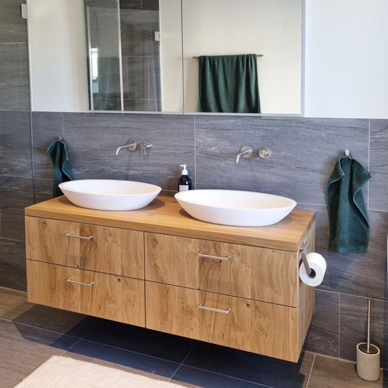 Modernes Badezimmer mit Holzwaschtisch und zwei Aufsatzwaschbecken.