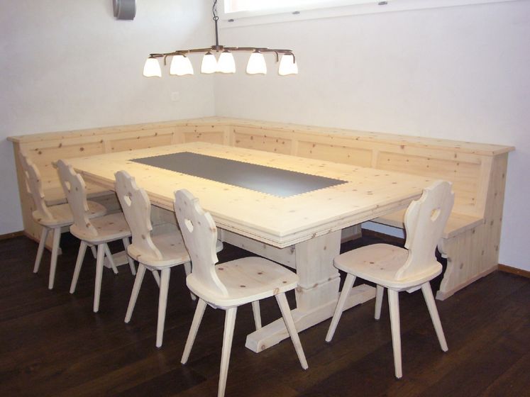 Holztisch mit Eckbank und Stühlen in einem modernen Esszimmer.