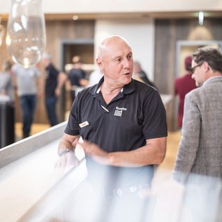 Ein Mitarbeiter von Stark AG berät Kunden im Showroom für Holzwerkstoffe.