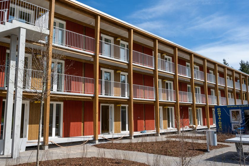 Moderne Holzkonstruktion eines mehrstöckigen Gebäudes mit Balkonen.