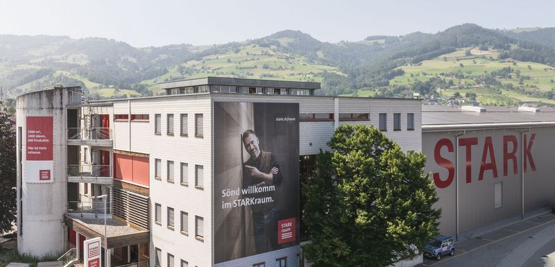 Stark AG Altstätten Gebäude vor grüner Hügellandschaft.