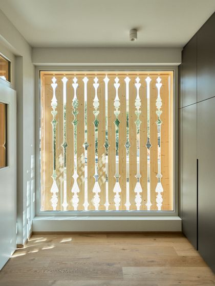 Dekorative Holzverkleidung an einem Fenster in einem modernen Innenraum.