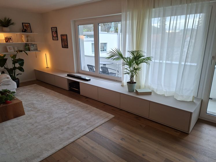 Modernes Wohnzimmer mit Holzboden und eleganten Möbeln.