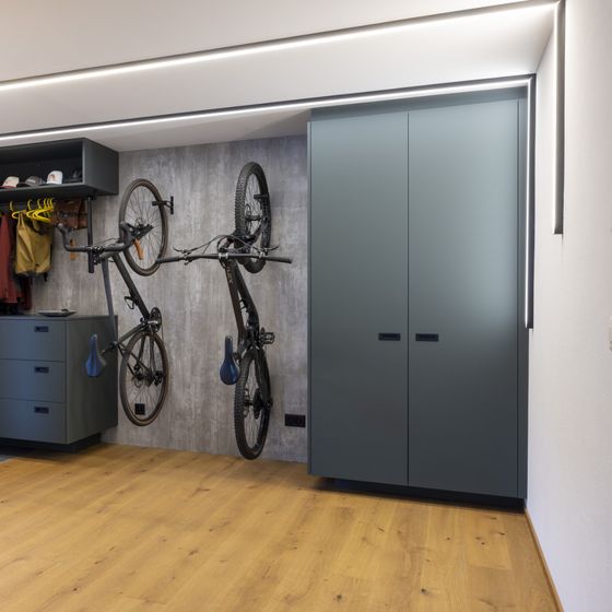 Moderner Innenraum mit Holzfussboden und aufgehängtem Fahrrad an der Wand.