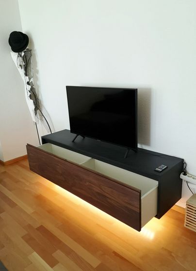 Moderner TV-Schrank mit Beleuchtung und Flachbildschirm.